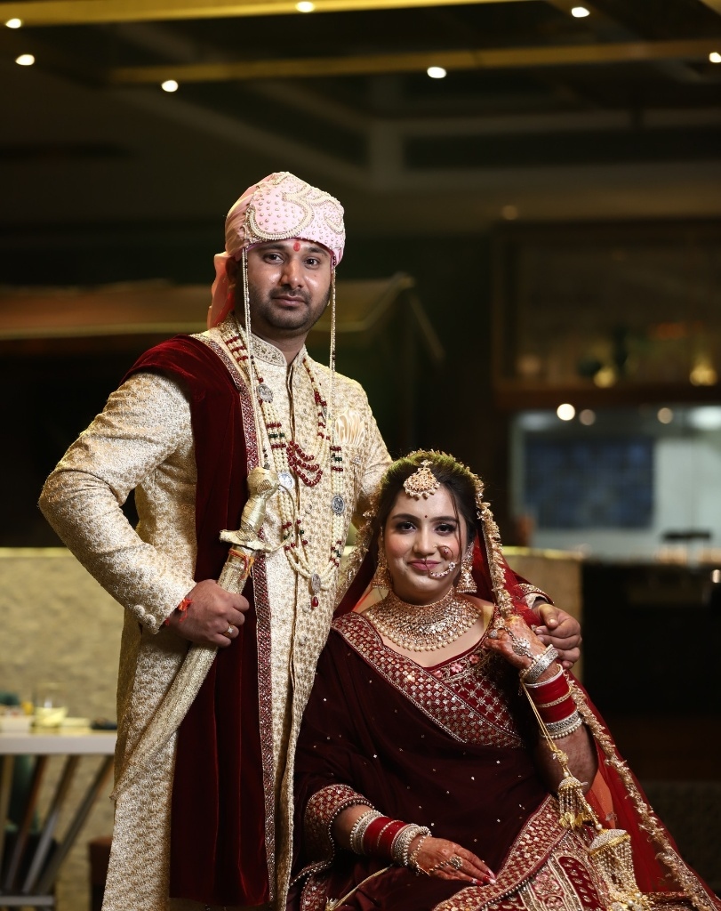 Traditional groom with sword and royal bride seated at Monu Studio Fotography